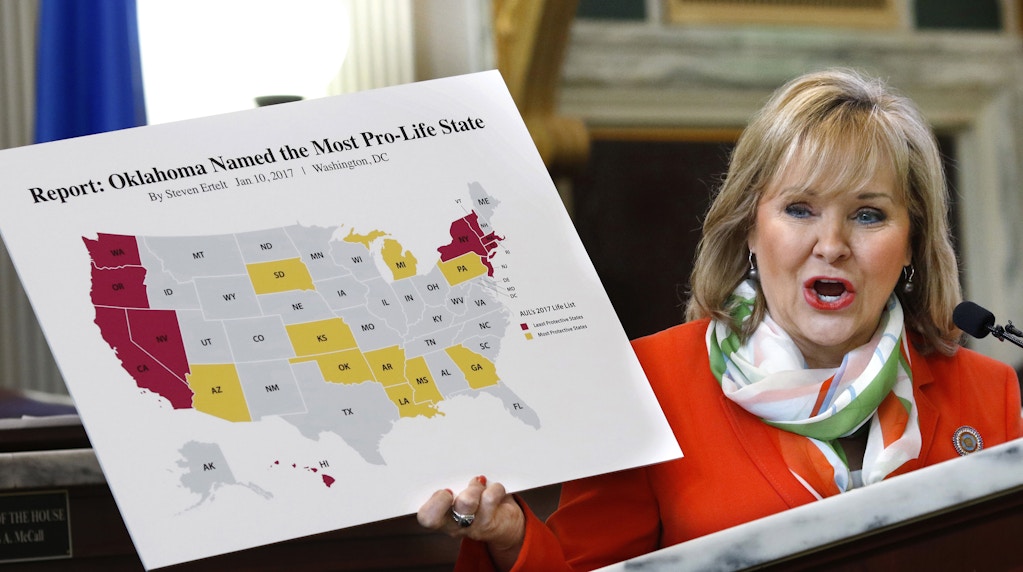 Oklahoma Gov. Mary Fallin shows the large crowd a map of the United States in which Oklahoma is declared the most anti-abortion state during her speech to  anti-abortion Oklahomans during Red Rose Day events, Wednesday, Feb. 8, 2017, at the state Capitol. ( Jim Beckel/The Oklahoman via AP)
