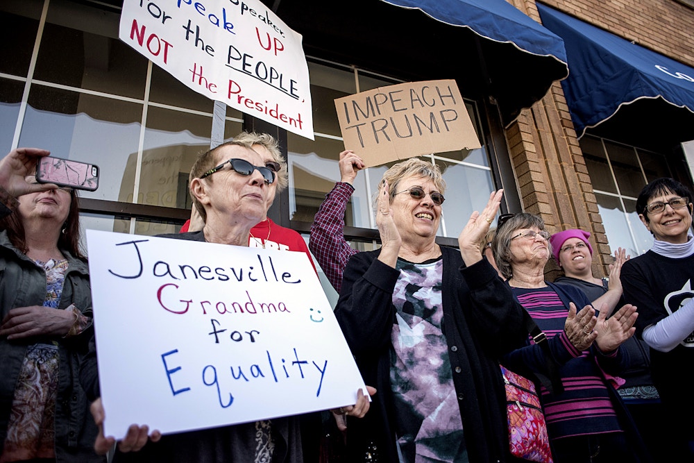 Protesters hold signs outside of House Speaker Paul Ryan's office on Main Street in downtown Janesville, Wis., Wednesday, Feb. 22, 2017. (Angela Major/The Janesville Gazette via AP)