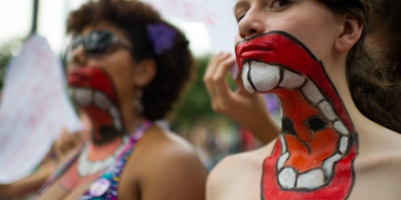 Women with their upper bodies painted pose as they take part in a protest against violence against women during the celebration of the International Women's Day on March 8, 2013, in Sao Paulo, Brazil. AFP PHOTO/YASUYOSHI CHIBA        (Photo credit should read YASUYOSHI CHIBA/AFP/Getty Images)