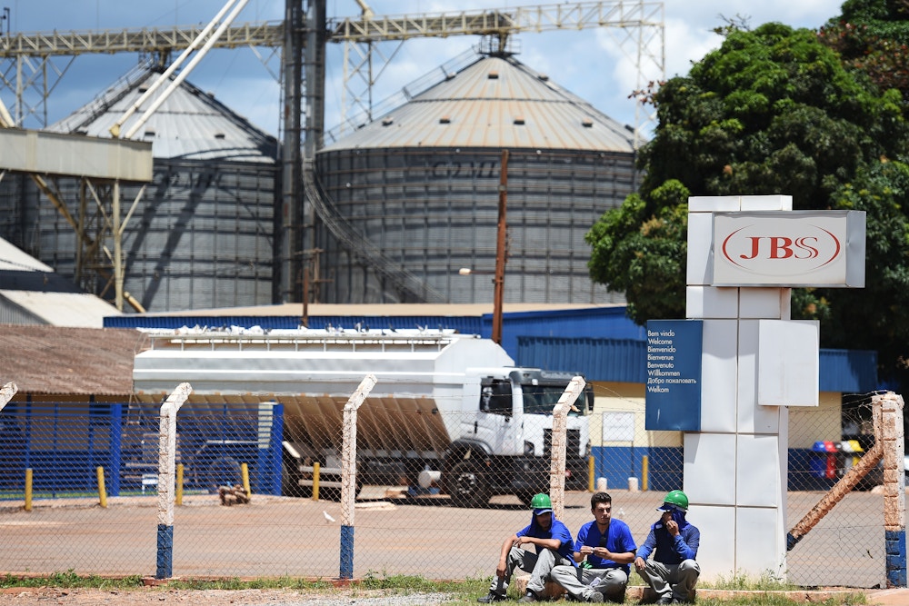 Workers take a rest at the entrence of JBS-Friboi chicken processing plant, in Samambaia, Federal District, Brazil on March 17, 2017.<br /><br /><br /><br />
Brazilian Federal police have dismantled, after two years of running the "weak flesh" operation, a vast network of adulterated food, involving major meat processing plants and inspectors who accepted bribes to approve products in bad condition for domestic consumption and exportation.  / AFP PHOTO / EVARISTO SA        (Photo credit should read EVARISTO SA/AFP/Getty Images)