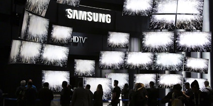 FILE - In this Thursday, Jan. 8, 2015, file photo, attendees watch a presentation at the Samsung booth at the International CES, in Las Vegas. For years, TV makers have focused on making pictures sharper by squeezing more pixels onto screens, but now their attention is shifting to improving the way sets display color, with a newish technology called HDR taking center stage. (AP Photo/Jae C. Hong, File)