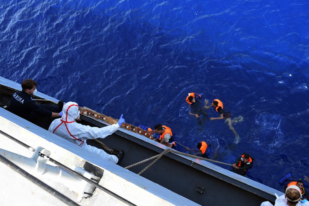 SICILIAN STRAIT, MEDITERRANEAN SEA - MAY 25: Italian marines rescue migrants from a capsized boat at Sicilian Strait, between Libya and Italy, in Mediterranean sea on May 25, 2016. The Italian Navy saved around 500 migrants as they found dead bodies of seven migrants in the sea during the operations. (Photo by Italian Navy / Marina Militare/Anadolu Agency/Getty Images)