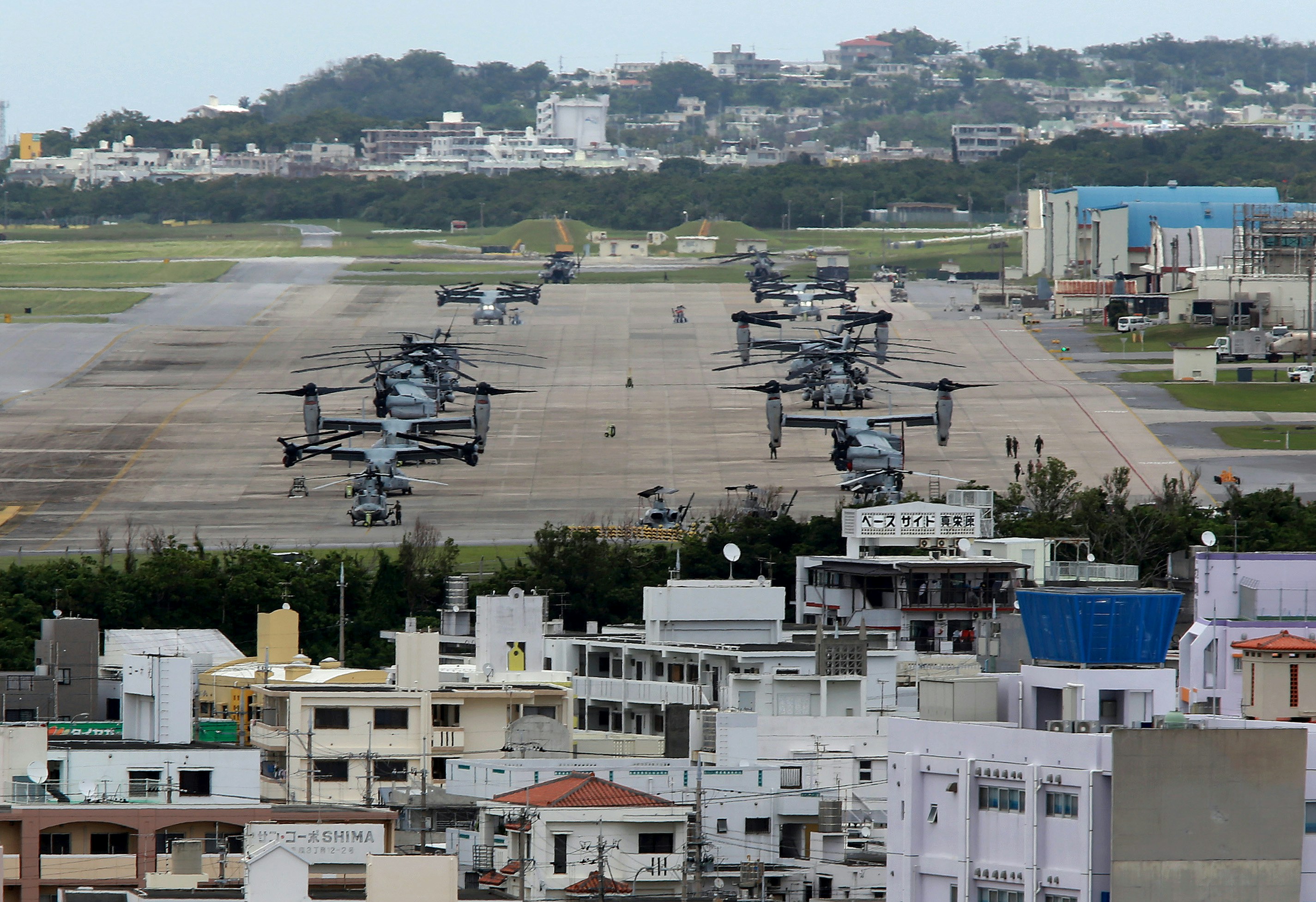 epa04756429 US Marine Corps MV-22 Osprey aircrafts are sitting on the tarmac at US Marine Corps Air Station Futenma surrounded by overcrowded residential areas in Ginowan on Okinawa Island, southwestern Japan, 19 May 2015. Japanese government just announced on May 12 that CV-22 Ospreys would be deployed to the U.S. Air Force's Yokota base on the outskirt of Tokyo. CV-22 Ospreys is for special operations forces, engage in low-altitude and nighttime flights, and the accident rate is three times higher than Marines MV-22 Ospreys. Japanese four local cities' leaders in Tokyo surrounding US Air Force's Yokota Base have expressed deep concern over the deployment of CV-22 Ospreys in 2017, as Pentagon announced on 18 May 2015 it had no plan to change Osprey operations in Japan after a CV-22 Osprey crash in Hawaii killing one and injuring 21 on last weekend.  EPA/HITOSHI MAESHIRO