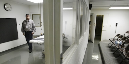 FILE - In this Tuesday, April 15, 2008 file photo, Terry Crenshaw, warden's assistant at the Oklahoma State Penitentiary, walks past a gurney in the execution chamber in McAlester, Okla. At right are rows of chairs for witnesses. A lawsuit filed on behalf of 21 Oklahoma death row inmates on Wednesday, June 25, 2014, seeks to halt any attempt to execute them using the state's current lethal injection protocols, which it claims presents a risk of severe pain and suffering. (AP Photo)