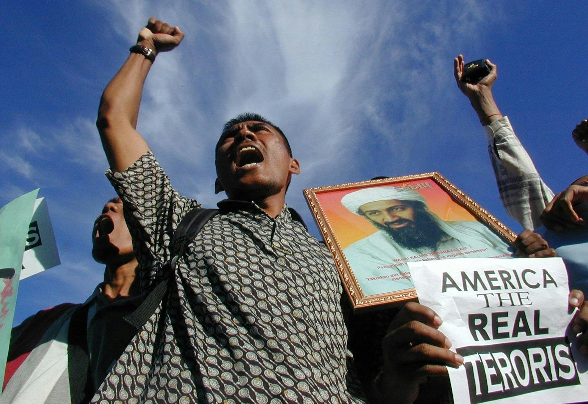 BANDA ACEH, INDONESIA:  A Muslim protestor holding a portrait of Saudi-dissident Osama bin Laden shout "Allah Akbar" during a protest in front of Baiturrahman mosque, Banda Aceh, 10 October 2001. The demonstrators are protesting against the US-led military strikes against Afghanistan.       AFP PHOTO (Photo credit should read AFP/Getty Images)