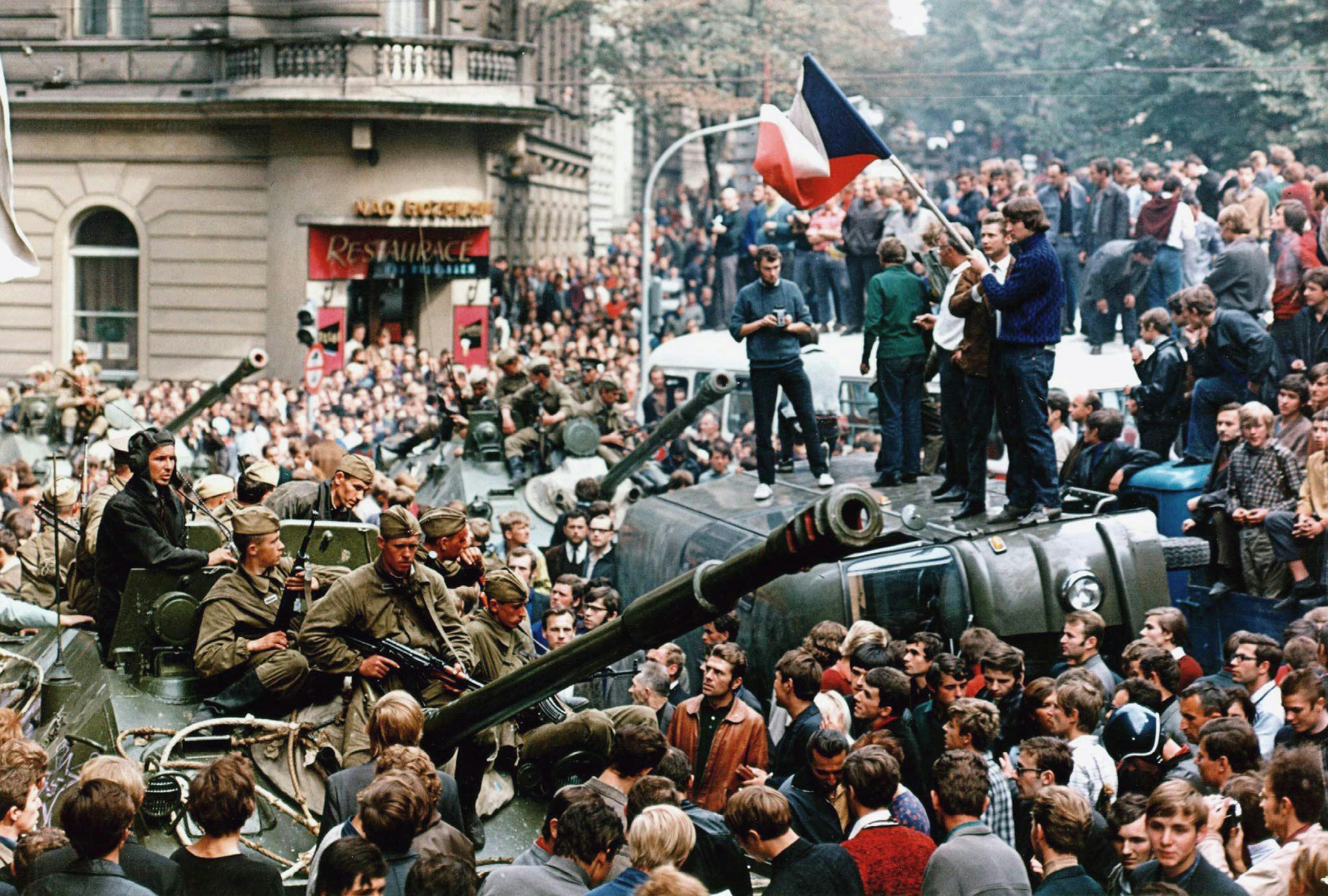 PRAGUE, CZECH REPUBLIC - AUGUST 21:  Czech youngsters holding a Czechoslovak flag stand atop an overturned truck as other Prague residents surround Soviet tanks in  Prague on 21 August 1968 as the Soviet-led invasion by the Warsaw Pact armies crushed the so called Prague Spring reform in former Czechoslovakia.  (Photo credit should read LIBOR HAJSKY/AFP/Getty Images)