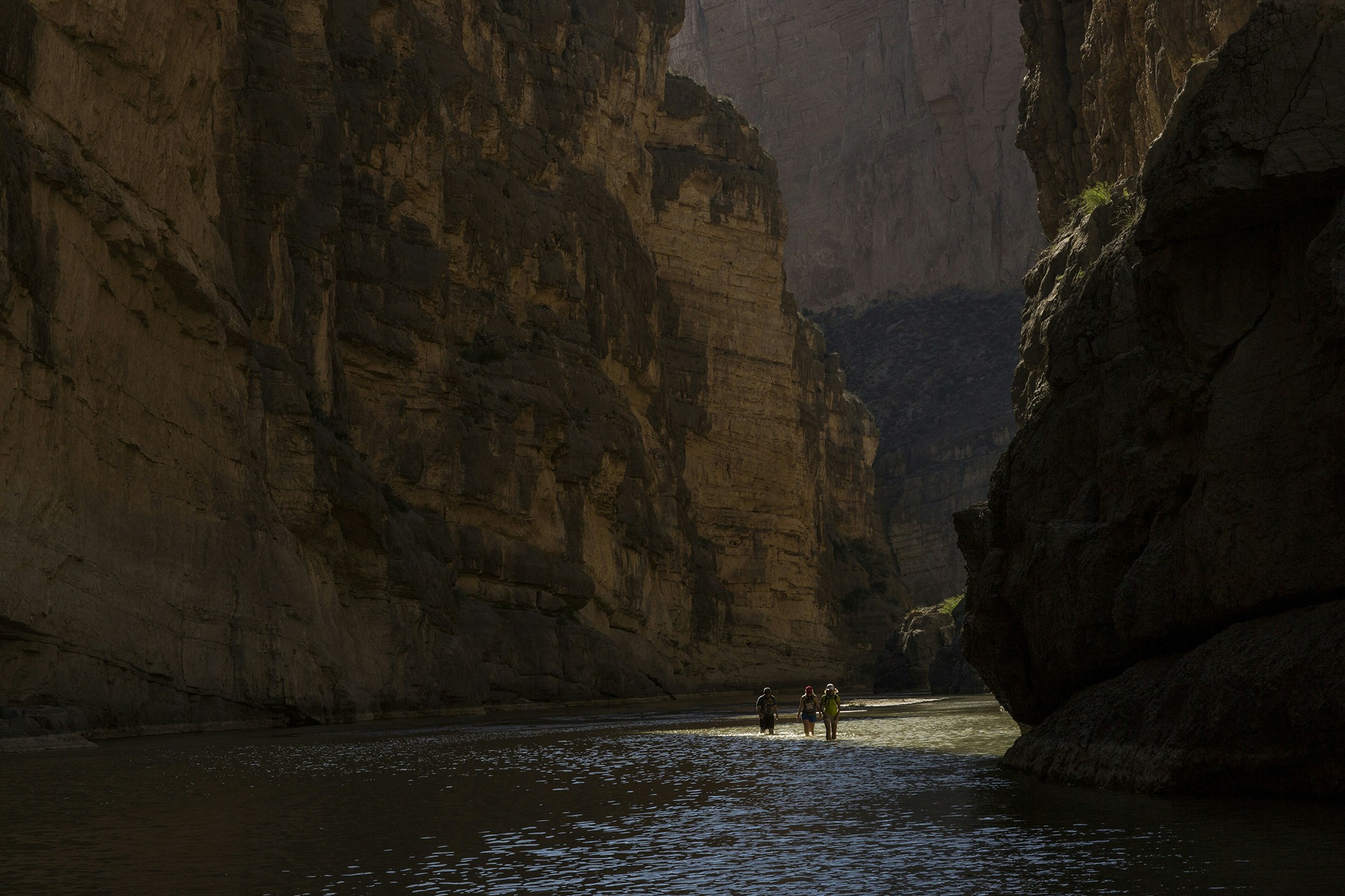 Tourists walk through Santa Elena Canyon, wading through the water of the Rio Grande, between Mexico, left, and the US, right, as they vacation at Big Bend National Park in Texas, Monday, March 27, 2017. Here the Rio Grande slides between two sheer cliff faces, one in Mexico and one in the United States, that tower 1,500 feet above the water. (AP Photo/Rodrigo Abd)