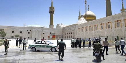 Police officers control the scene, around of shrine of late Iranian revolutionary founder Ayatollah Khomeini, after an assault by several attackers in Tehran, just outside Tehran, Iran, Wednesday, June 7, 2017. Suicide bombers and gunmen stormed into Iran's parliament and targeted the shrine of Ayatollah Ruhollah Khomeini on Wednesday, killing a security guard and wounding several other people in rare twin attacks, with the siege at the legislature still underway. (AP Photo/Ebrahim Noroozi)