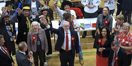 Britain's Labour party leader Jeremy Corbyn, bottom center, waves after arriving for the declaration at his constituency in London, Friday, June 9, 2017. Britain voted Thursday in an election that started out as an attempt by Prime Minister Theresa May to increase her party's majority in Parliament ahead of Brexit negotiations but was upended by terror attacks in Manchester and London during the campaign's closing days. (AP Photo/Frank Augstein)