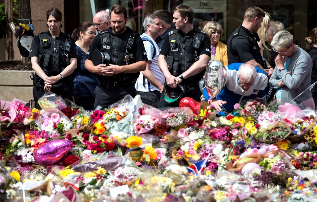 Police officers join members of the public to view the flowers and messages of support in St Ann's Square in Manchester, northwest England on May 31, 2017, placed in tribute to the victims of the May 22 terror attack at the Manchester Arena. / AFP PHOTO / OLI SCARFF        (Photo credit should read OLI SCARFF/AFP/Getty Images)