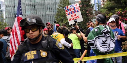 PORTLAND, OR - JUNE 04: Right wing demonstrators hold up signs disparaging illegal immigrants at a rally on June 4, 2017 in Portland, Oregon. A protest dubbed 'Trump Free Speech' by organizers was met by a large contingent of counter-demonstrators who viewed the protest as a promotion of racism. The demonstrations come in the wake of the recent violent attack on the city's MAX train line when Ricky Best, 53, and Taliesin Namkai-Meche, 23, were stabbed to death and Micah Fletcher,21, was severely injured after they tried to protect two teenage girls, one of whom was wearing a hijab, from being harassed with racial taunts by suspect Jeremy Christian.  (Photo by Natalie Behring/Getty Images)