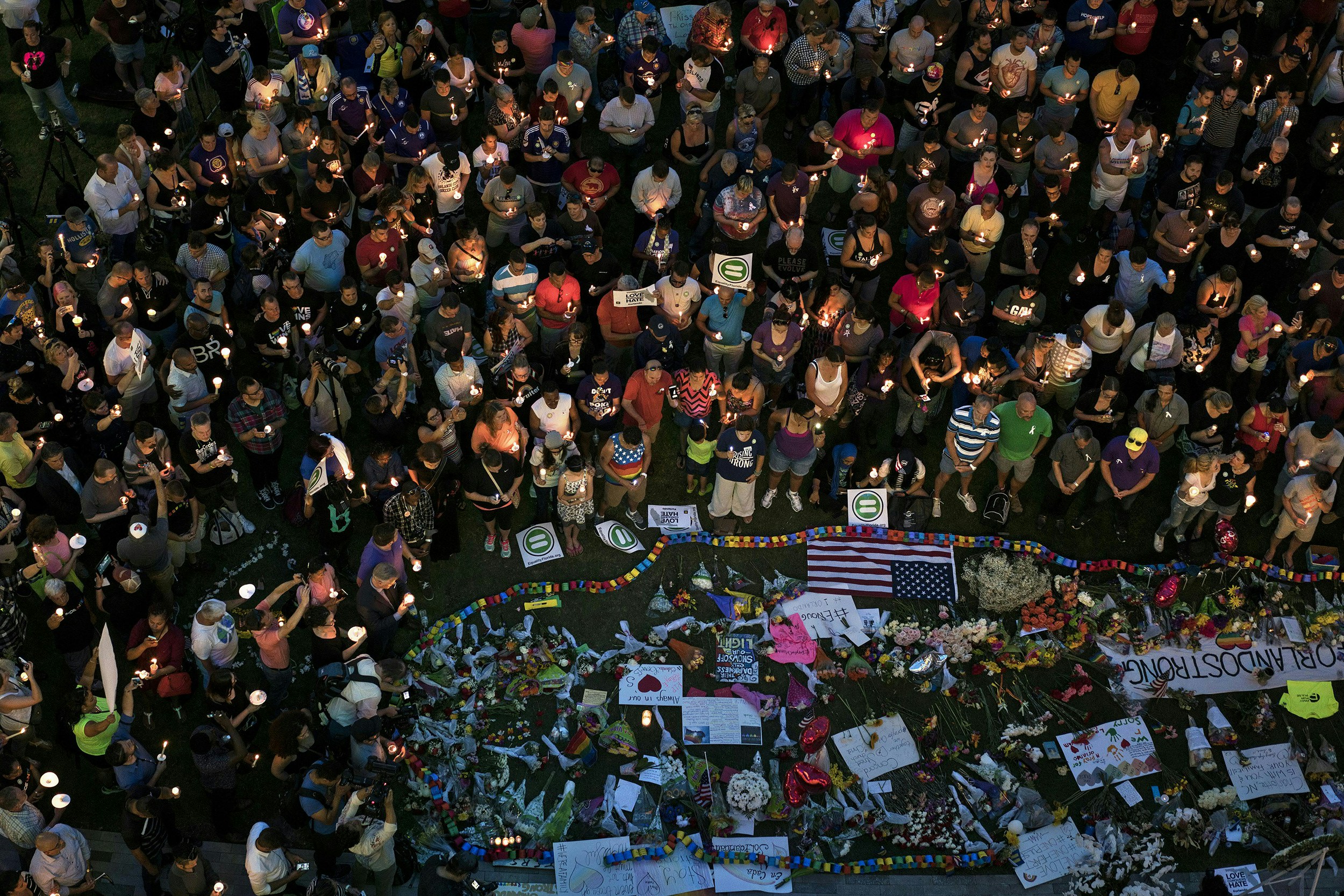 TOPSHOT - Mourners hold candles while observing a moment of silence during a vigil outside the Dr. Phillips Center for the Performing Arts for the mass shooting victims at the Pulse nightclub June 13, 2016 in Orlando, Florida.The American gunman who launched a murderous assault on a gay nightclub in Orlando was radicalized by Islamist propaganda, officials said Monday, as they grappled with the worst terror attack on US soil since 9/11. / AFP / Brendan Smialowski (Photo credit should read BRENDAN SMIALOWSKI/AFP/Getty Images)