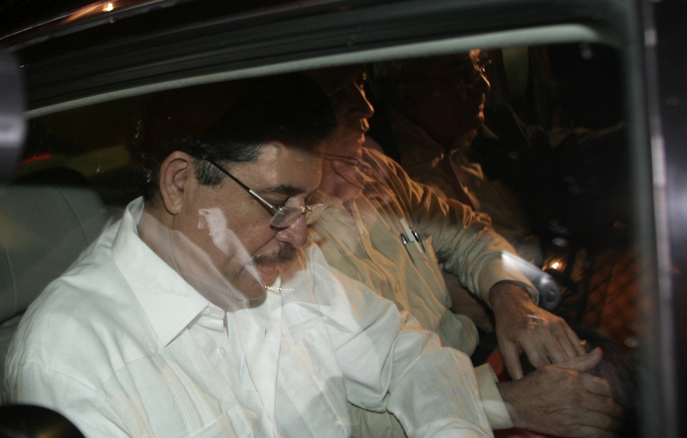 Ousted Honduras' President Manuel Zelaya, left, looks down inside a car on his way to the airport where he will board a flight to Nicaragua on the outskirts of San Jose, Sunday, June 28, 2009. Soldiers seized Honduras' national palace and sent the President Zelaya into exile in Costa Rica on Sunday, hours before a disputed constitutional referendum. Zelaya, an ally of Venezuelan President Hugo Chavez, said he was victim of a coup. Honduras' Congress sworn in Sunday congressional leader Roberto Micheletti as the country's new President. (AP Photo/Kent Gilbert)