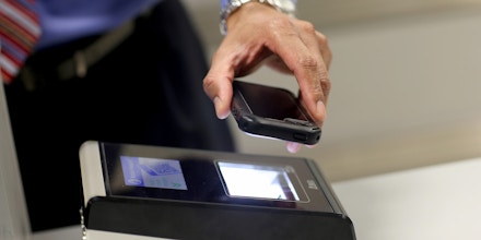 MIAMI, FL - MARCH 04: A phone is passed over a scanner during a demonstration in the use of the new mobile app for expedited passport and customer screening being unveiled for international travelers arriving at Miami International Airport on March 4, 2015 in Miami, Florida. Miami-Dade Aviation Department and U.S. Customs and Border Protection (CBP) unveiled a new mobile app for expedited passport and customs screening. The app for iOS and Android devices allows U.S. citizens and some Canadian citizens to enter and submit their passport and customs declaration information using their smartphone or tablet and to help avoid the long waits in the exit lanes.  (Photo by Joe Raedle/Getty Images)
