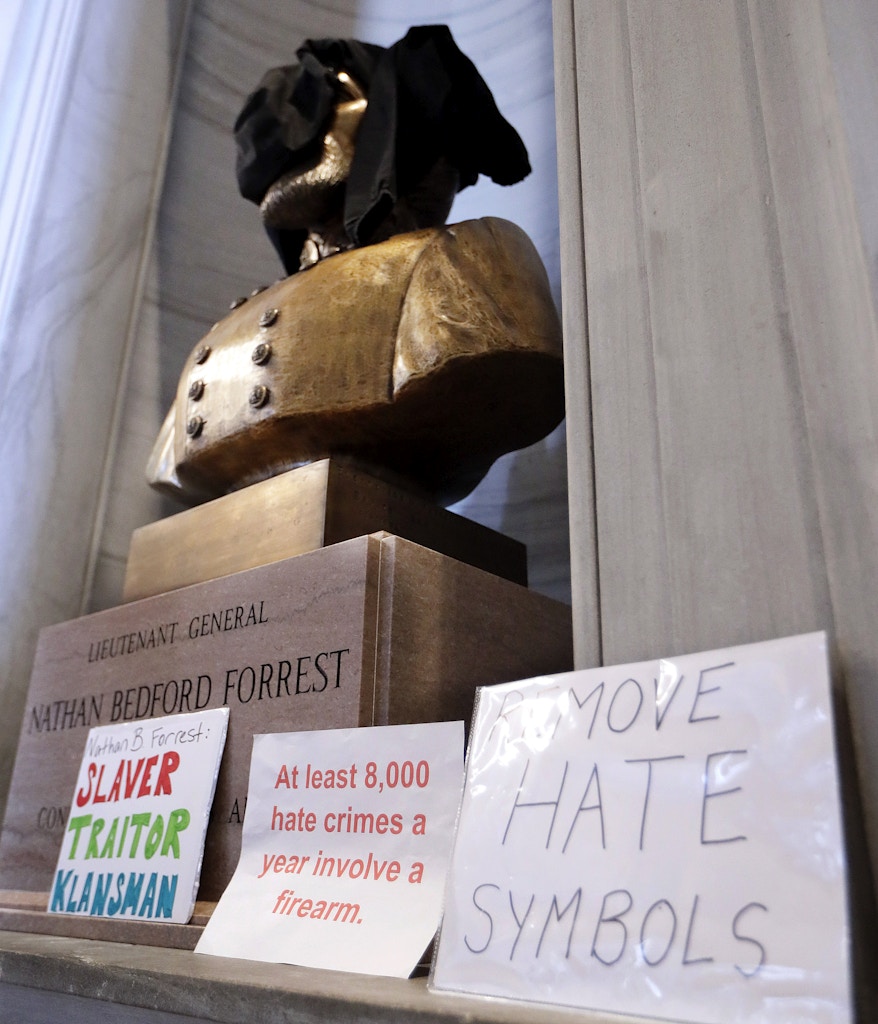 Signs stand in front of a bust of Nathan Bedford Forrest and a sweatshirt covers its face during a protest Monday, Aug. 14, 2017, in Nashville, Tenn. Protesters called for the removal of the bust, which is displayed in the hallway outside the House and Senate chambers. Violence in Virginia this weekend has given rise to a new wave of efforts to remove or relocate Confederate monuments. (AP Photo/Mark Humphrey)