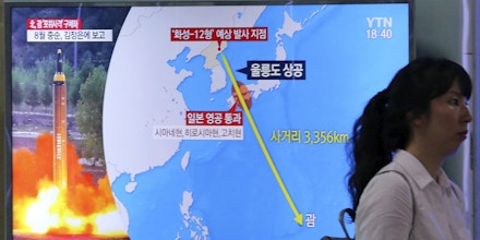 A woman passes by a TV screen showing a local news program reporting on North Korea's threats to strike Guam with missiles at the Seoul Train Station in Seoul, South Korea, Thursday, Aug. 10, 2017. North Korea has announced a detailed plan to launch a salvo of ballistic missiles toward the U.S. Pacific territory of Guam, a major military hub and home to U.S. bombers. If carried out, it would be the North's most provocative missile launch to date. The signs at left top read 