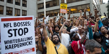 NEW YORK, NY - AUGUST 23: Activists raise their fists as they rally in support of NFL quarterback Colin Kaepernick outside the offices of the National Football League on Park Avenue, August 23, 2017 in New York City. During the NFL season last year, Kaepernick caused controversy by kneeling during the National Anthem at games to protest racial oppression and police brutality. Kaepernick is currently a free agent and some critics and analysts claim NFL teams don't want to sign him due to his public display of his political beliefs. (Photo by Drew Angerer/Getty Images)