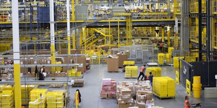 ROBBINSVILLE, NJ - AUGUST 1:  Employees work at the Amazon Fulfillment Center on August 1, 2017 in Robbinsville, New Jersey.  The more than 1 million square feet facility holds tens of millions of products, features more than 14 miles of conveyor belts, and employs more than 4,000 workers who pick, pack, and ship orders.  Tomorrow Amazon will host a jobs fair to hire 50,000 positions in their fulfillment centers nationwide.  (Photo by Mark Makela/Getty Images)
