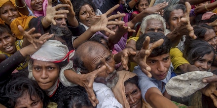 Rohingya Muslims, who crossed over from Myanmar into Bangladesh, stretch their arms out to collect rice bags distributed by aid workers near Balukhali refugee camp, Bangladesh, Friday, Sept. 22, 2017. More than 420,000 Rohingya refugees have fled from Myanmar to Bangladesh in less than a month, with most ending up in camps in the Bangladeshi district of Cox's Bazar, which already had hundreds of thousands of Rohingya refugees who had fled prior rounds of violence in Myanmar. (AP Photo/Dar Yasin)
