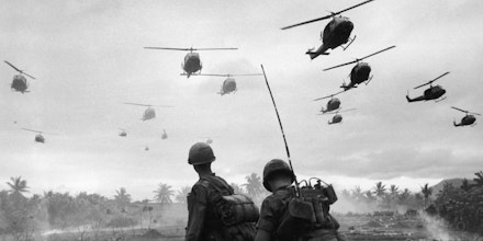 The second wave of combat helicopters of the 1st Air Cavalry Division fly over an RTO and his commander on an isolated landing zone during Operation Pershing, a search and destroy mission on the Bong Son Plain and An Lao Valley of South Vietnam, during the Vietnam War. The two American soldiers are waiting for the second wave to come in.   (Photo by Patrick Christain/Getty Images)