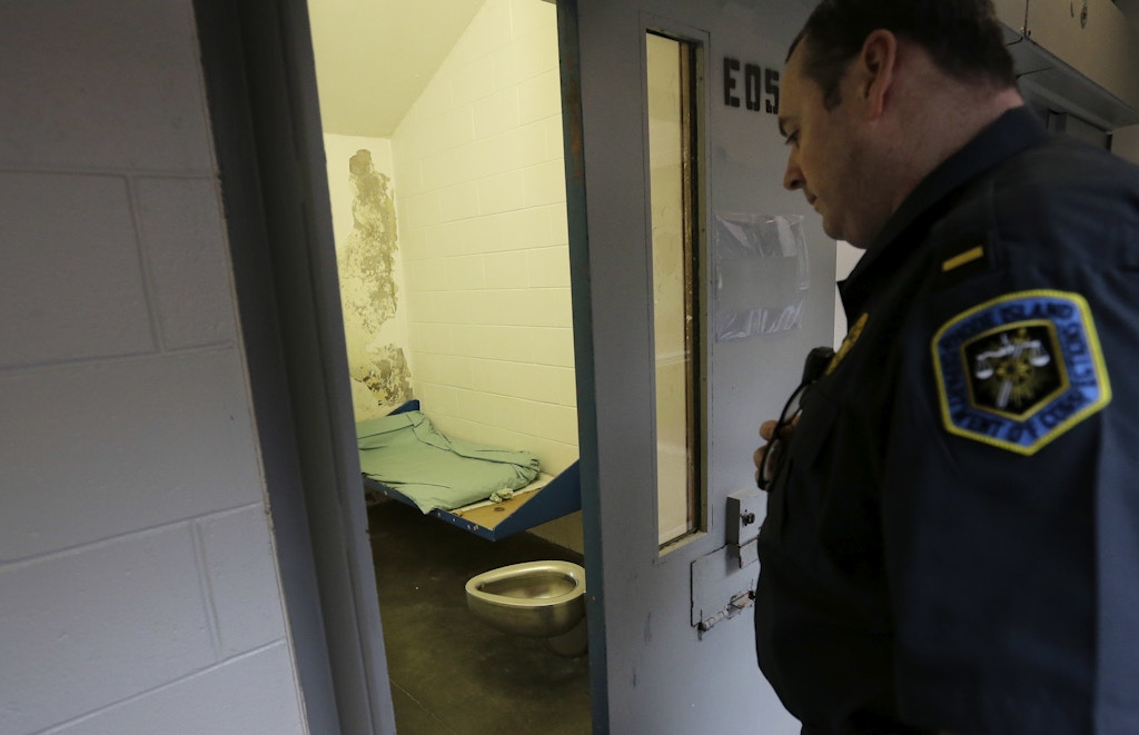 In this Thursday, Feb. 25, 2016 photo correctional officer Lt. Joshua Macomber looks into a cell in what prison officials describe as a disciplinary confinement area rather than solitary confinement, at the Rhode Island Department of Corrections High Security Center, in Cranston, R.I. Some lawmakers in Rhode Island are pushing to curb the use of solitary confinement in state prisons. Prison officials say they already have standards limiting the use of what they call disciplinary confinement, but some advocates say it's been used arbitrarily. (AP Photo/Steven Senne)