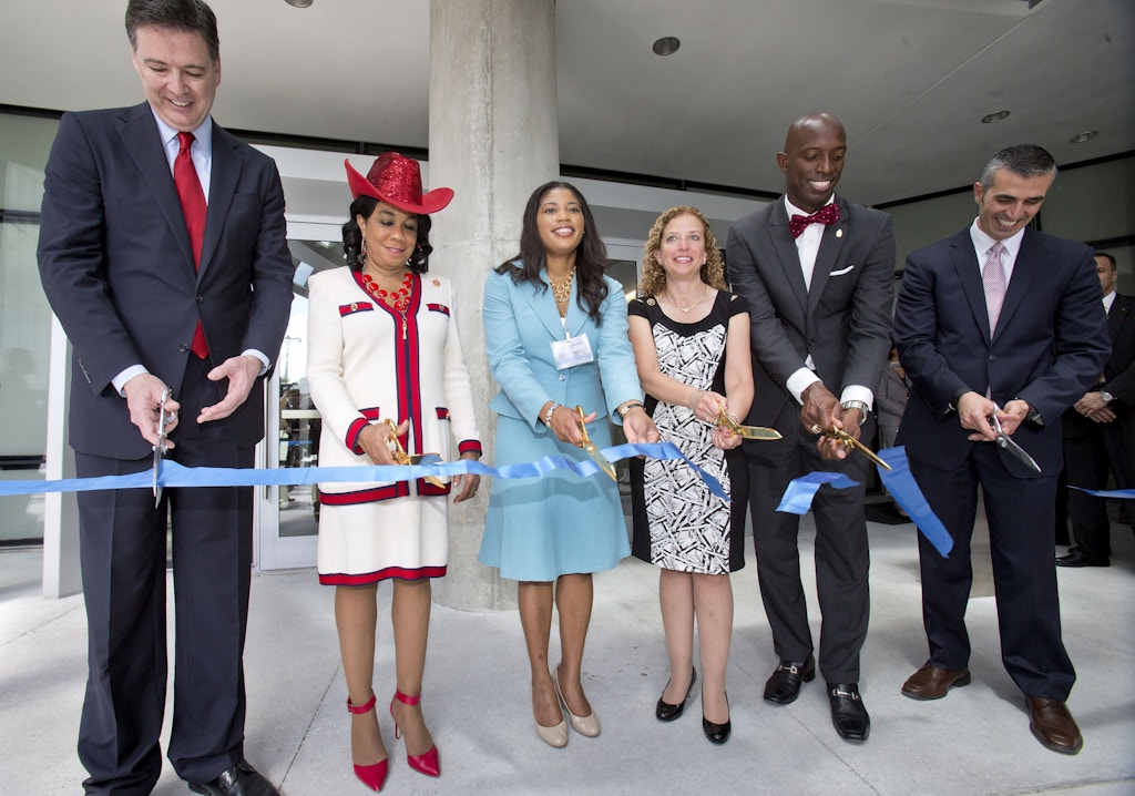 Dignitaries cut a ribbon to mark the dedication of the Federal Bureau of Investigation's new $194 million South Florida field office, Friday, April 10, 2015, in Miramar, Fla. The office is named for agents Benjamin P. Grogan and Jerry L. Dove, who were killed in an April 11, 1986, shootout with heavily armed bank robbers south of Miami. Five other FBI agents were wounded in what remains the bureau's bloodiest single day. Three survivors attended Friday's ceremony. From left, FBI Director James Comey, U.S. Rep. Frederica Wilson, acting GSA Administrator Denise Roth, U.S. Rep. Debbie Wasserman Schultz, Miramar, Fla. Mayor Wayne Messam, and George Piro, Special Agent in Charge, FBI Miami. (AP Photo/Wilfredo Lee, Pool)