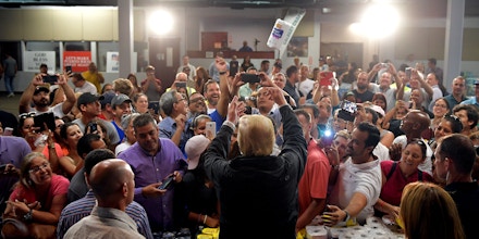 US President Donald Trump takes part in a food and suplly distribution at the Cavalry Chapel in Guaynabo, Puerto Rico on October 3, 2017.Nearly two weeks after Hurricane Maria thrashed through the US territory, much of the islands remains short of food and without access to power or drinking water. / AFP PHOTO / MANDEL NGAN (Photo credit should read MANDEL NGAN/AFP/Getty Images)