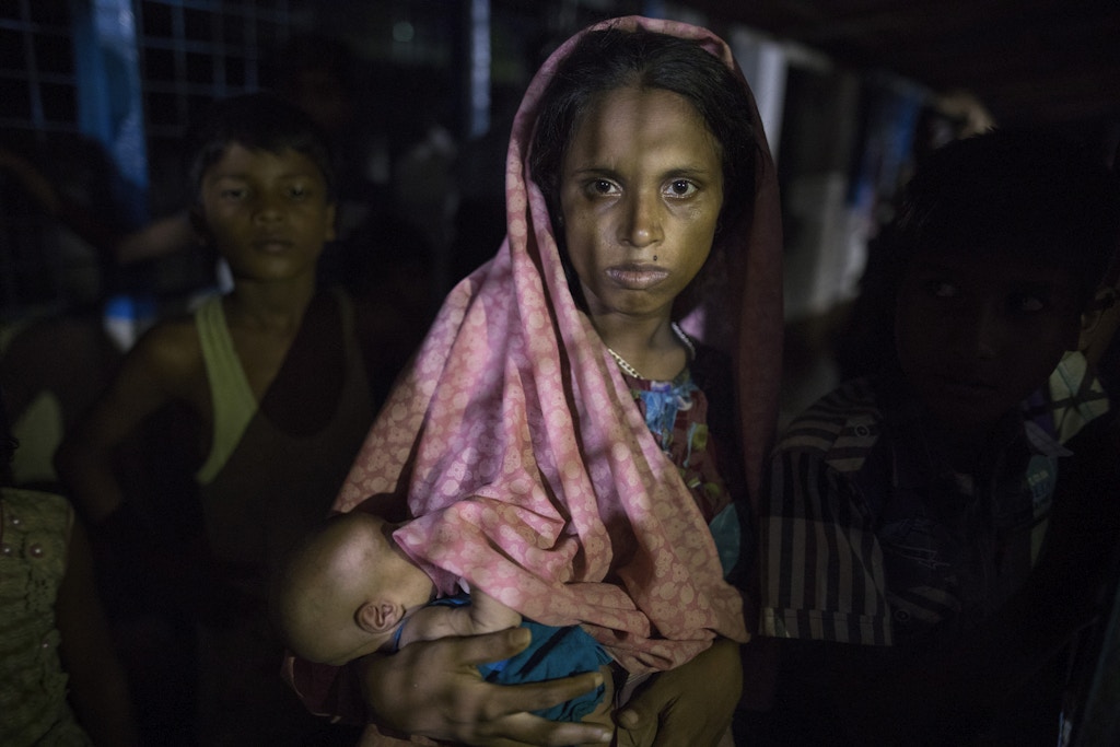KUTUPALONG, BANGLADESH - SEPTEMBER 29:  Hasina Begum, age 18, holds her newborn baby, 8 days old,  born while she was walking in the forest escaping from Myanmar September 29, 2017 in Kutupalong , Bangladesh. She is now living inside a makeshift shelter packed with new arrivals. Over a half a million Rohingya refugees have fled into Bangladesh from the horrific violence in Rakhine state in Myanmar causing a humanitarian crisis. (Photo by Paula Bronstein/Getty Images)