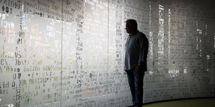 Eugene Kaspersky, Russian antivirus programs developer and chief executive of Russia's Kaspersky Lab, watches trough a window decorated with programming code's symbols at his company's headquarters in Moscow, Russia, Saturday, July 1, 2017. Kaspersky says he's ready to have his company's source code examined by U.S. government officials to help dispel long-lingering suspicions about his company's ties to the Kremlin. (AP Photo/Pavel Golovkin)