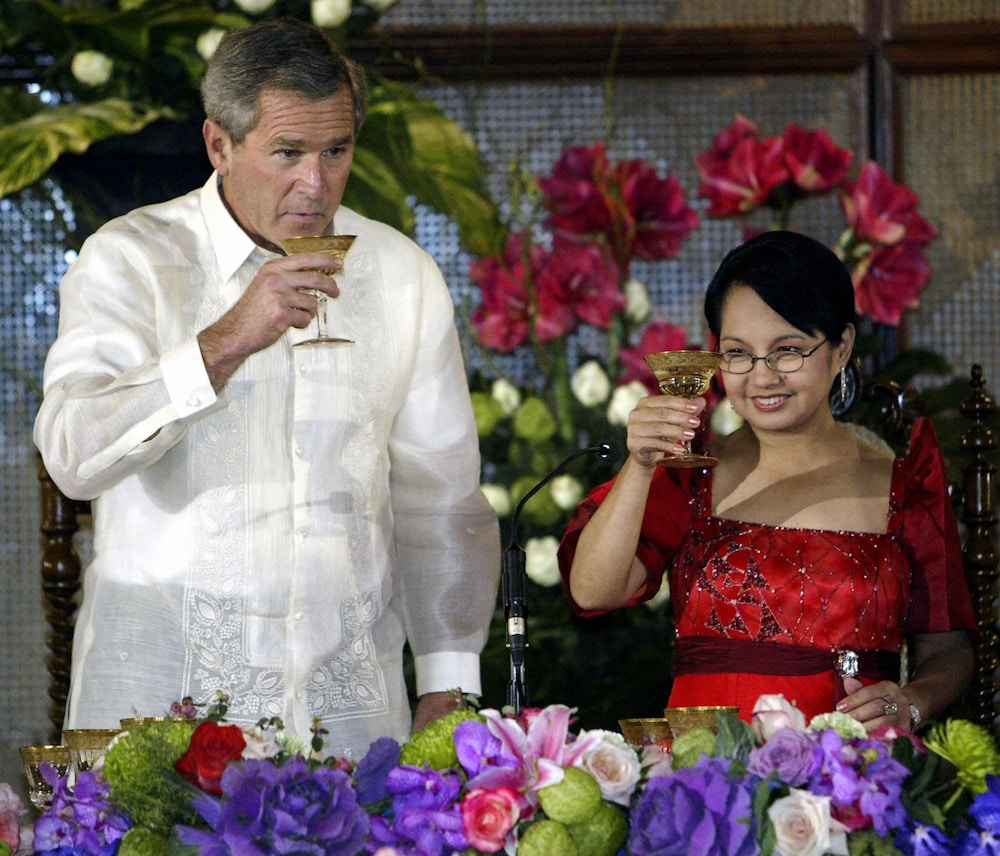 MANILA, PHILIPPINES:  US President George W. Bush (L) toasts with Philippine President Gloria Macapagal Arroyo at the Malacanang Palace in Manila, 18 October 2003, during his State Visit to the Philippines as part of his 9-day trip in Asia.  President Bush on 18 October pledged funds and training to help the Philippines military quash regional extremists as he made an eight hour state visit to this staunch war-on-terrorism ally.    AFP Photo/Paul J. RICHARDS  (Photo credit should read PAUL J.RICHARDS/AFP/Getty Images)