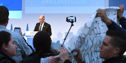 Protesters show banners and protest during the speech of US Governor of California, Jerry Brown at the launch event at the US climate action center on November 11, 2017 during the COP23 United Nations Climate Change Conference in Bonn, Germany. / AFP PHOTO / PATRIK STOLLARZ        (Photo credit should read PATRIK STOLLARZ/AFP/Getty Images)