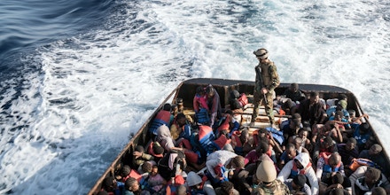 A Libyan coast guardsman stands on a boat during the rescue of 147 illegal immigrants attempting to reach Europe off the coastal town of Zawiyah, 45 kilometres west of the capital Tripoli, on June 27, 2017.More than 8,000 migrants have been rescued in waters off Libya during the past 48 hours in difficult weather conditions, Italy's coastguard said on June 27, 2017. / AFP PHOTO / Taha JAWASHI (Photo credit should read TAHA JAWASHI/AFP/Getty Images)