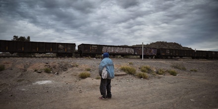A Honduran migrant watches the train go by in the community of Caborca in Sonora state, Mexico, on January 13, 2017.Hundreds of Central American and Mexican migrants attempt to cross the US border daily. / AFP / ALFREDO ESTRELLA (Photo credit should read ALFREDO ESTRELLA/AFP/Getty Images)