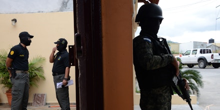 Members of the Honduran Directorate for the Fight against Drug Trafficking (DLCN) and the Military Police take part in an operation to seize 32 real estate, 15 vehicles and nine commercial companies of six Honduran police officers charged in absentia in New York late last month, in Tegucigalpa on July 14, 2016.The police officers were indicted in a cocaine smuggling and weapons conspiracy linked to a son of the troubled country's former president. The six defendants, aged 39 to 46, were charged a month after Fabio Lobo, son of former Honduran president Porfirio Lobo, pled guilty to conspiring to import cocaine into the United States. US prosecutors say the officers agreed to give cocaine safe passage through Honduras in exchange for nearly $1 million in bribes from purported Mexican drug smugglers, who were in fact undercover US agents. / AFP / ORLANDO SIERRA (Photo credit should read ORLANDO SIERRA/AFP/Getty Images)