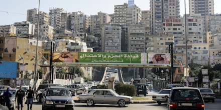A picture taken on November 10, 2017 shows a banner bearing the images of Saudi King Salman bin Abdulaziz (R) and Crown Prince Mohammed bin Salman (L) hanging on a pedestrian crossing bridge in the northern Lebanese port city of Tripoli, between them a caption reading in Arabic 