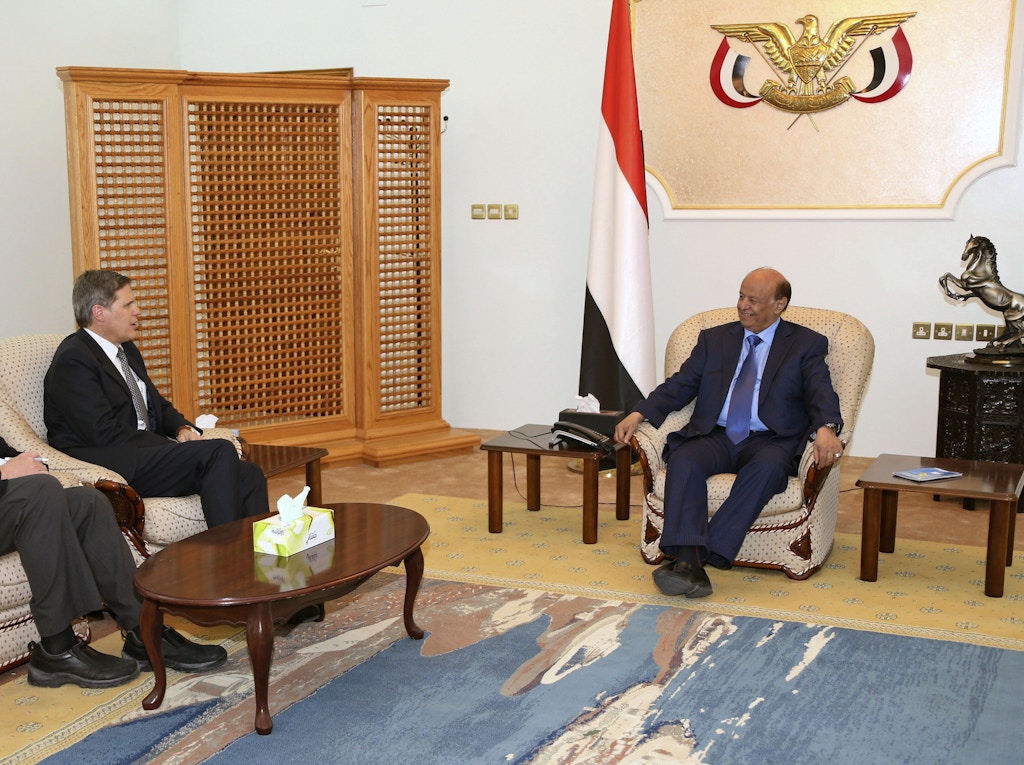 Yemen's President Abd-Rabbu Mansour Hadi (R) talks with U.S. Ambassador to Yemen Matthew H. Tueller (C) during a meeting in the southern port city of Aden March 2, 2015. Hadi accused his predecessor on Sunday of conspiring with Iran to scuttle a 2011 deal backed by Gulf states to transfer power to him in cooperation with the Shi'ite Muslim Houthi group. Hadi, who assumed office in 2012 after Ali Abdullah Saleh resigned following months of protests against his 33-year rule, fled to the southern port city of Aden last month after the Houthis battled their way to the presidential palace. REUTERS/Stringer (YEMEN - Tags: POLITICS CIVIL UNREST) - GM1EB321MQC01