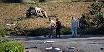 TOPSHOT - Police and forensic experts inspect the wreckage of a car bomb believed to have killed journalist and blogger Daphne Caruana Galizia close to her home in Bidnija, Malta, on October 16, 2017. The force of the blast broke her car into several pieces and catapulted the journalist's body into a nearby field, witnesses said. She leaves a husband and three sons.Caruana Galizia's death comes four months after Prime Minister Joseph Muscat's Labour Party won a resounding victory in a general election he called early as a result of scandals to which Caruana Galizia's allegations were central. / AFP PHOTO / STR / Malta OUT (Photo credit should read STR/AFP/Getty Images)