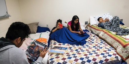 Carmela's children spend most of their time now on their phones playing games or watching videos. Carmela Hernandez, an undocumented Mexican immigrant who faces a deportation order along with her four children Fidel, 15, Kayri, 13, Joselyn, 11, and Edwin, 11, found temporary sanctuary from immigration officials by moving her family in early December into a small basement room at the historic African-American Church of the Advocate in North Philadelphia, Pennsylvania, December 18, 2017. Charles Mostoller for The Intercept