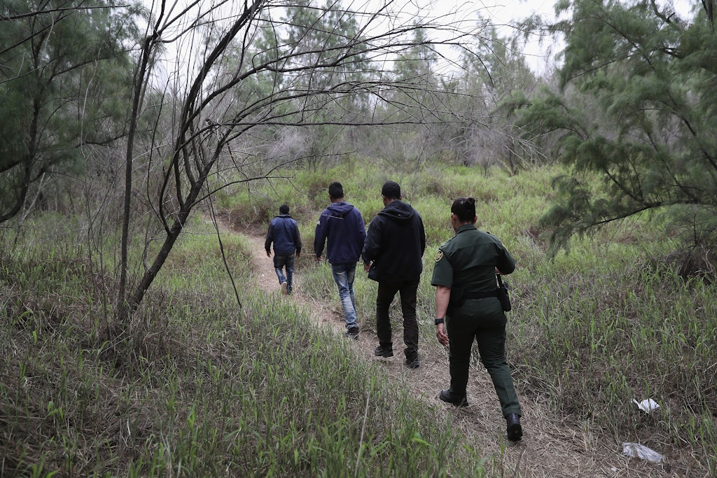 MCALLEN, TX - JANUARY 04:  A U.S. Border Patrol agent takes Central American immigrants into custody on January 4, 2017 near McAllen, Texas. Thousands of families and unaccompanied children, most from Central America, are crossing the border illegally to request asylum in the U.S. from violence and poverty in their home countries. The number of immigrants coming across has surged in advance of President-elect Donald Trump's inauguration January 20. He has pledged to build a wall along the U.S.-Mexico border.  (Photo by John Moore/Getty Images)