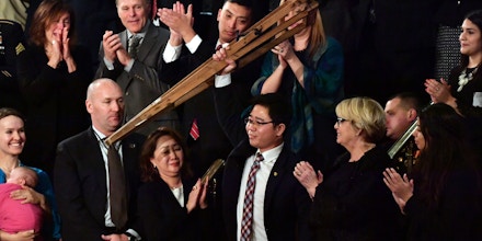 North Korean defector Ji Seong-ho raises his crutches as he is recognized by US President Donald Trump during the State of the Union address at the US Capitol in Washington, DC, on January 30, 2018. / AFP PHOTO / Nicholas Kamm        (Photo credit should read NICHOLAS KAMM/AFP/Getty Images)