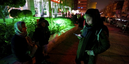 People phone and wait in the streets in Tehran overnight on December 21, 2017, after an earthquake was felt in the Iranian capital.The quake measuring 5.2 magnitude struck shortly before 11:30 pm (2000 GMT), according to the seismological centre of the University of Tehran. The epicentre of the tremor was located about 40 kilometres (25 miles) west of the capital. / AFP PHOTO / ATTA KENARE (Photo credit should read ATTA KENARE/AFP/Getty Images)