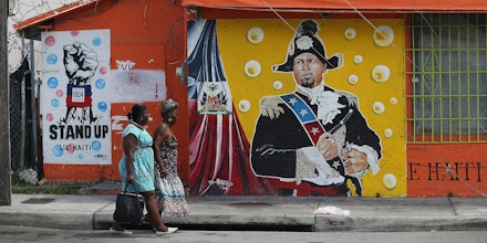 MIAMI, FL - MAY 17:  Women walk past a mural in the Little Haiti neighborhood on May 17, 2017 in Miami, Florida. People living in the neighborhood are concerned about the outcome of the decision on extending the Temporary Protected Status for Haitians living in the United States because it would possibly mean having friends and family of theirs being sent back to Haiti. 50,000 Haitians have been eligible for TPS and now the Trump administration has until May 23 to make a decision on extending TPS for Haitians. If it is allowed to expire on July 22, current TPS holders could possibly be deported.  (Photo by Joe Raedle/Getty Images)