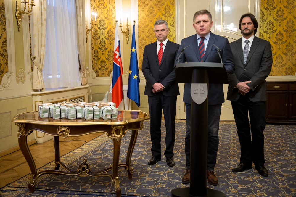 Slovak Prime Minister Robert Fico (C) is flanked by Slovak Police President Tibor Gaspar (L) and Slovak Interior Minister Robert Kalinak (R) as they stand next to bundles of Euro banknotes during a press conference on the murder case of a leading journalist who investigated high-profile tax fraud on February 27, 2018 in Bratislava, Slovakia.<br /><br /><br /> The body of Jan Kuciak, a 27-year-old reporter for the aktuality.sk news portal owned by Axel Springer and Ringier, was on Sunday (February 25, 2018) discovered alongside that of his fiancee Martina Kusnirova at their home in Velka Maca, 65 kilometres (40 miles) east of the Slovak capital Bratislava. Prime Minister Robert Fico said his government was offering one million euros ($1.2 million) for information leading to the killers' capture. / AFP PHOTO / VLADIMIR SIMICEK        (Photo credit should read VLADIMIR SIMICEK/AFP/Getty Images)
