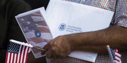 A new US citizen holds an information packet at a naturalization ceremony at Alexandria City Hall in Alexandria, Virginia on September 12, 2017.Each year, the United States Citizenship and Immigration Services (USCIS) welcomes approximately 680,000 citizens during naturalization ceremonies across the United States and around the world. / AFP PHOTO / ANDREW CABALLERO-REYNOLDS (Photo credit should read ANDREW CABALLERO-REYNOLDS/AFP/Getty Images)