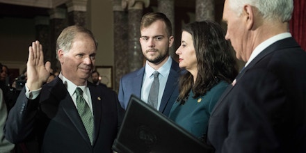 US Democratic Senator from Alabama Doug Jones is ceremonially sworn in by Vice President Mike Pence (R) at the Capitol in Washington, DC, on January 3, 2018 as wife Louise and son Carson look on.Jones, a civil rights champion and political novice, defeated the Christian conservative Roy Moore, a former Alabama judge who failed to overcome damaging accusations of sexual misconduct including molesting a teenage girl. Jones's upset victory does not change the balance of power in the 100-member Senate chamber, but it trims the Republican Party's majority to 51-49. / AFP PHOTO / NICHOLAS KAMM (Photo credit should read NICHOLAS KAMM/AFP/Getty Images)