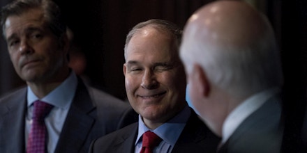 Environmental Protection Agency Administrator Scott Pruitt, center, winks at National Automobile Dealers Association president and CEO Peter Welch, right, as he takes the podium to speak at a news conference at the Environmental Protection Agency in Washington, Tuesday, April 3, 2018, on his decision to scrap Obama administration fuel standards. Also pictured is Global Automakers president and CEO John Bozzella, left. (AP Photo/Andrew Harnik)