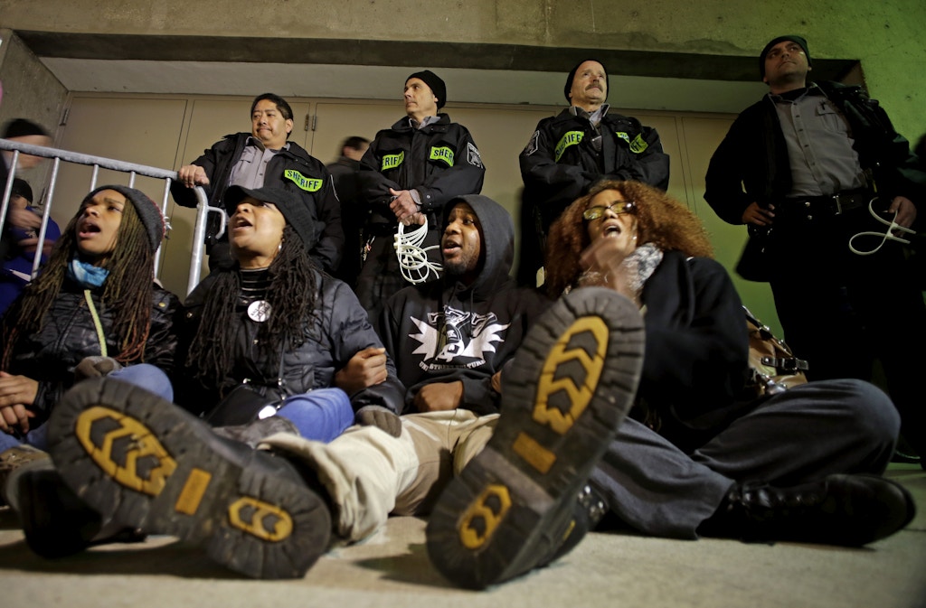 Protesters yell outside the Bradley Center before an NBA basketball game between the Milwaukee Bucks and the Charlotte Hornets Tuesday, Dec. 23, 2014, in Milwaukee. The group is protesting Monday's announcement  that no charges against former police office Christopher Manney were filed in the fatal shooting of Dontre Hamilton. (AP Photo/Morry Gash)