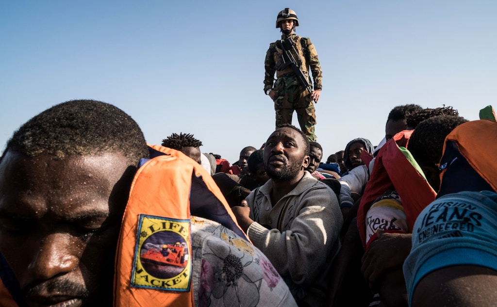A Libyan coast guardsman stands on a boat during the rescue of 147 illegal immigrants attempting to reach Europe off the coastal town of Zawiyah, 45 kilometres west of the capital Tripoli, on June 27, 2017.<br /><br /><br /><br /><br /><br /> More than 8,000 migrants have been rescued in waters off Libya during the past 48 hours in difficult weather conditions, Italy's coastguard said on June 27, 2017. / AFP PHOTO / Taha JAWASHI        (Photo credit should read TAHA JAWASHI/AFP/Getty Images)