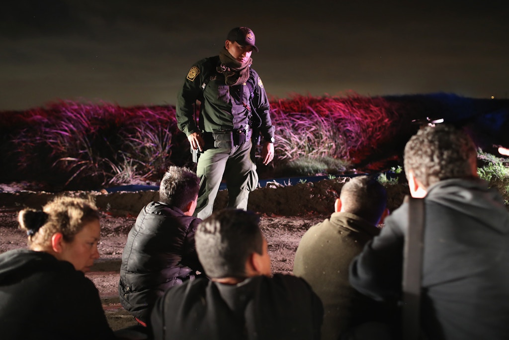 MCALLEN, TX - FEBRUARY 23:  A U.S. Border Patrol agent watches over a group of undocumented immigrants on February 23, 2018 in McAllen, Texas. The agents captured the group of Central American immigrants shortly after they rafted across the border from Mexico into Texas. (Photo by John Moore/Getty Images)