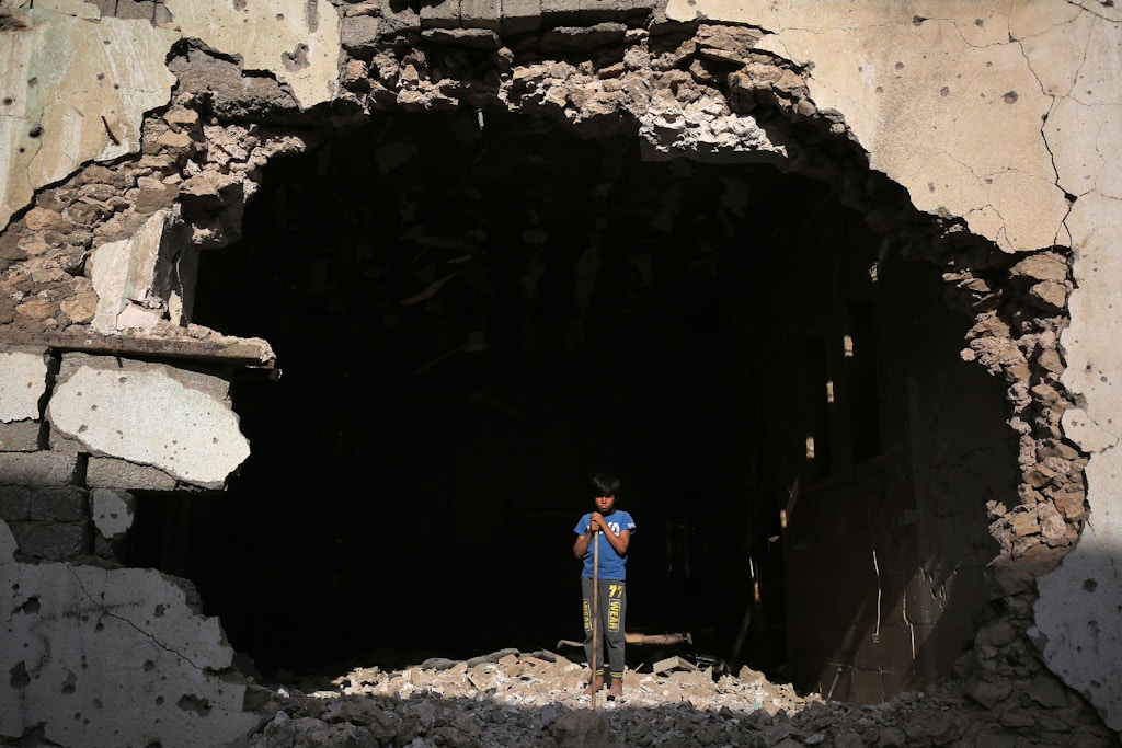 An Iraqi boy stands at the entrance of a destroyed building in the old city of Mosul on March 14, 2018, eight months after the Iraqi government forces retook the city from the control of the Islamic State (IS) group. / AFP PHOTO / AHMAD AL-RUBAYE        (Photo credit should read AHMAD AL-RUBAYE/AFP/Getty Images)